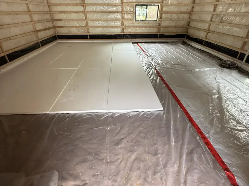 Pole barn interior with vapour barrier laid and the first section of slab poured