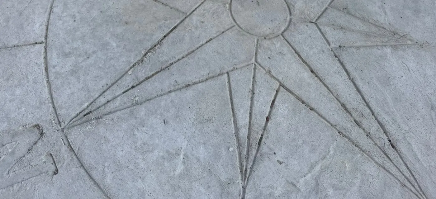 Stamped compass rose detail set into a decorative concrete floor