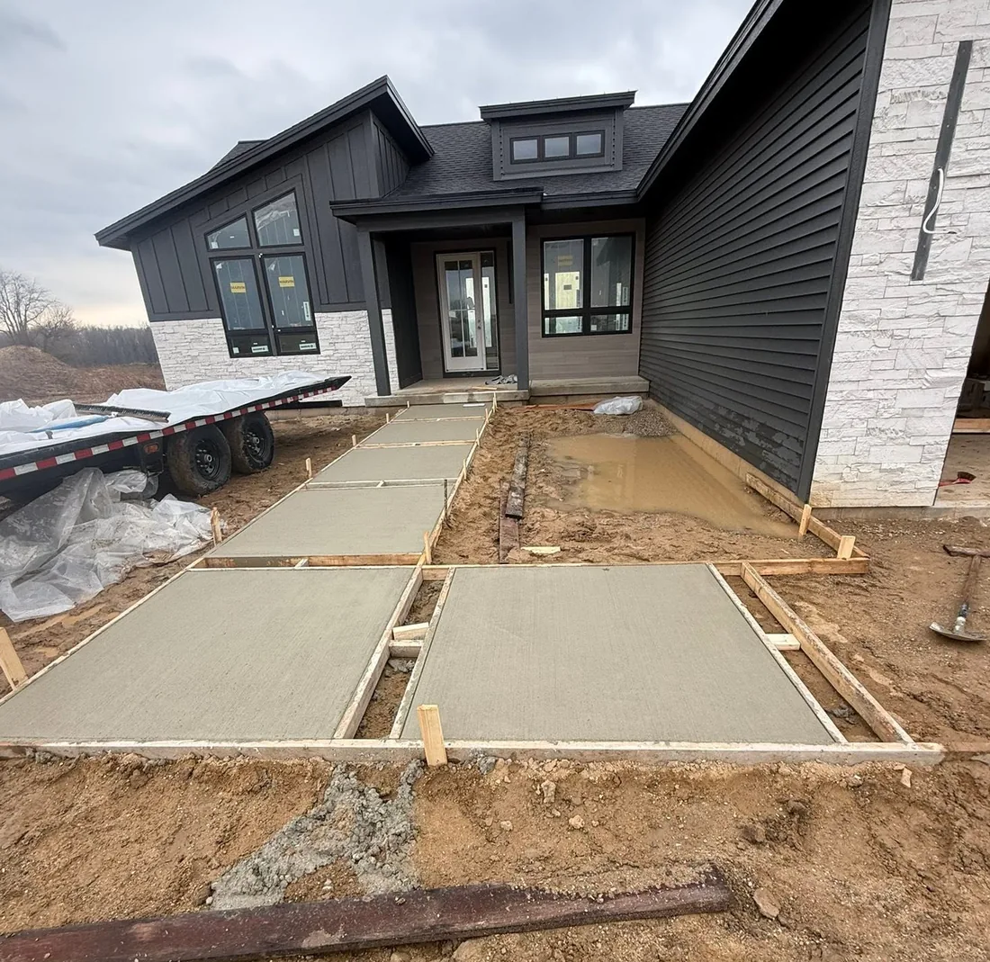 Concrete walkway and entry slabs formed and poured at a modern black farmhouse